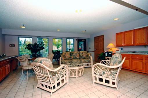 A living room with white furniture and a large window.