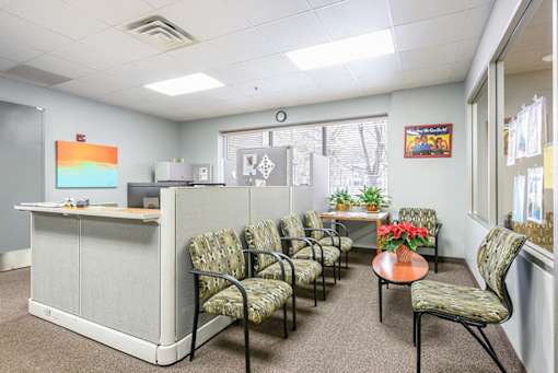 A waiting room with chairs and a desk.
