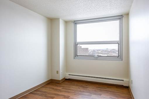 A room with a window overlooking a cityscape.