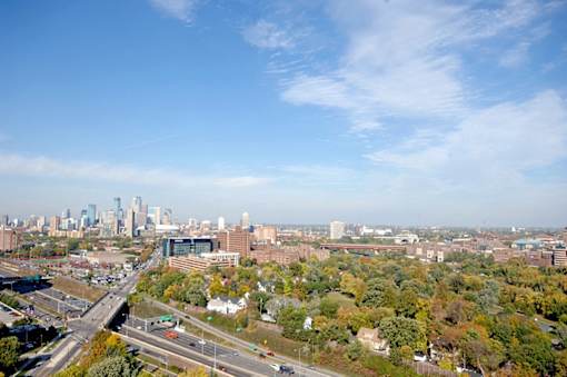 A cityscape with a highway and buildings in the background.