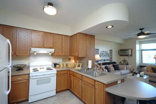A kitchen with wooden cabinets and a white stove top oven.