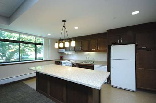 A kitchen with a white counter top and wooden cabinets.