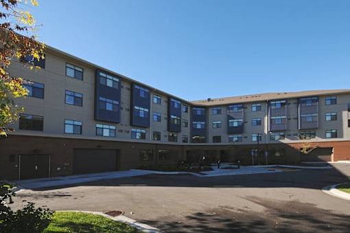 A large multi-story building with a parking lot in front.