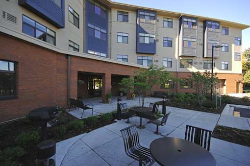 A courtyard with a table and chairs in front of a building.
