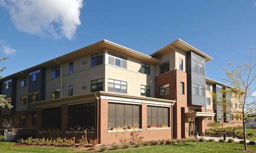 A modern two-story house with a large front yard.