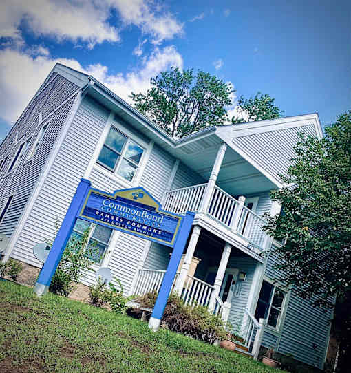 A blue and white house with a sign that says "Common Bond" on it.