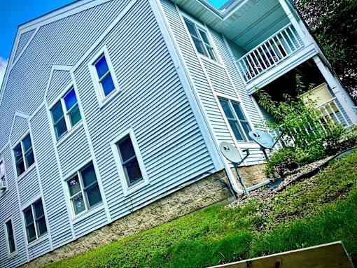 A house with a blue siding and a white balcony.