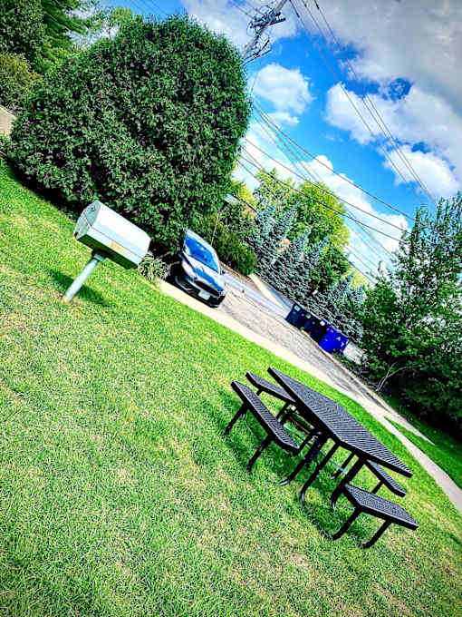 A picnic table is in the foreground of a grassy area.