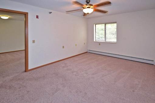 A room with a ceiling fan and a window.