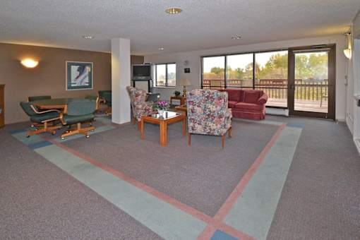 A living room with a couch, chairs, and a television.