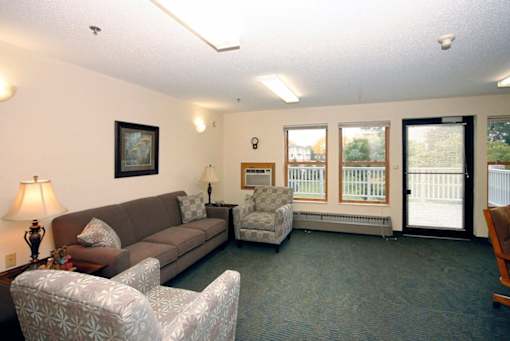A living room with a couch, chair, and lamp.
