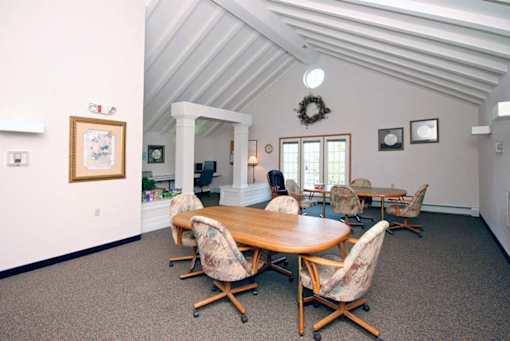 A room with a round table and chairs.