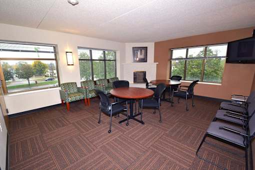 A conference room with a table surrounded by chairs.