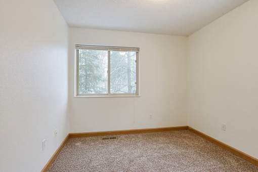 A room with a window and carpeted floor.