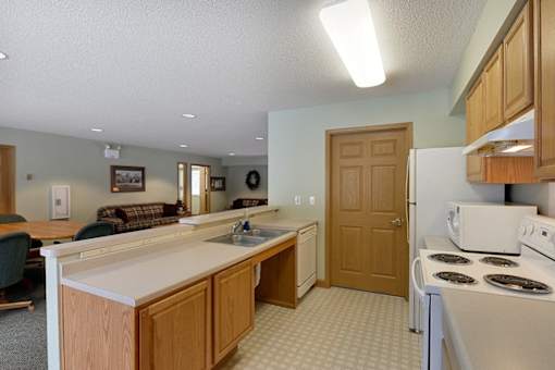 A kitchen with a white stove and wooden cabinets.