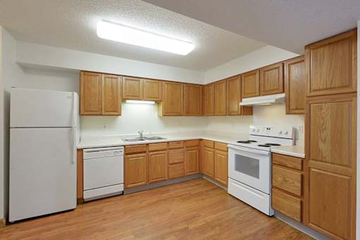 A kitchen with wooden cabinets and white appliances.