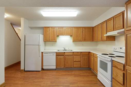 A kitchen with wooden cabinets and white appliances.
