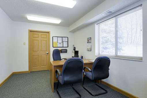 Two chairs are in front of a desk with a computer.