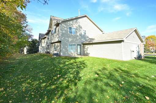 A house with a grey roof and a green lawn in front.