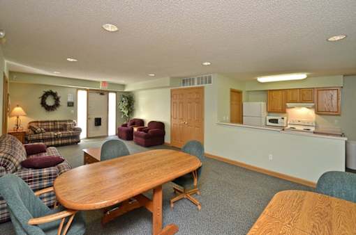 A living room with a couch, chairs, and a dining table.