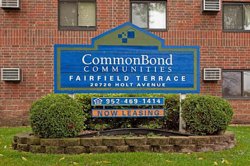 A sign for CommonBond Communities Fairfield Terrace in front of a brick building.