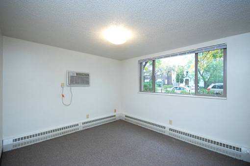 A room with a window and a wall-mounted air conditioner unit.