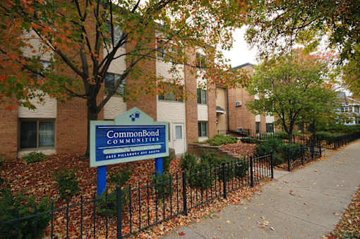 A sign for CommonBond Communities is in front of a brick building.
