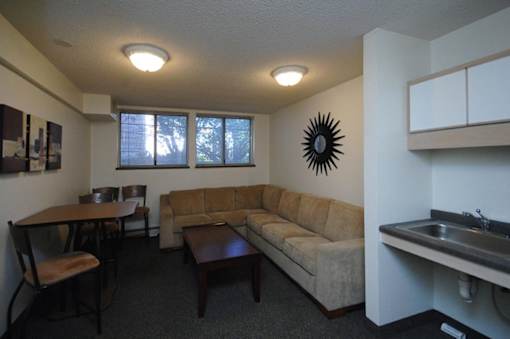 A living room with a couch, table, and chairs.