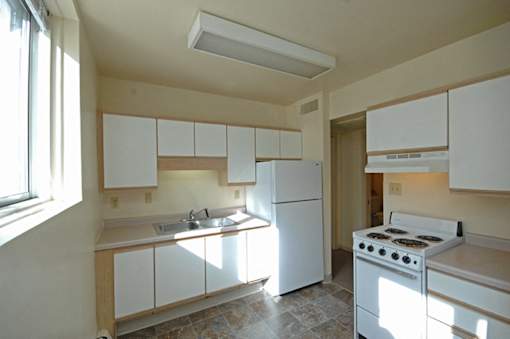 A kitchen with white appliances and cabinets.
