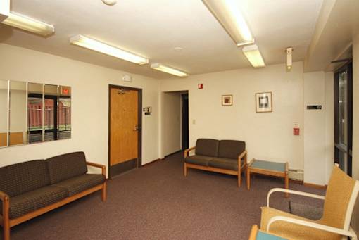 A waiting room with two couches and a chair.