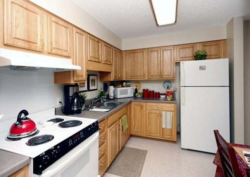 A kitchen with wooden cabinets and a white refrigerator.
