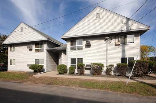 A two-story house with a white exterior and a grey roof.