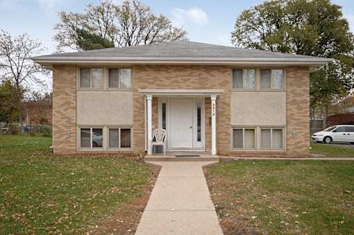 A brick house with a white door and windows.