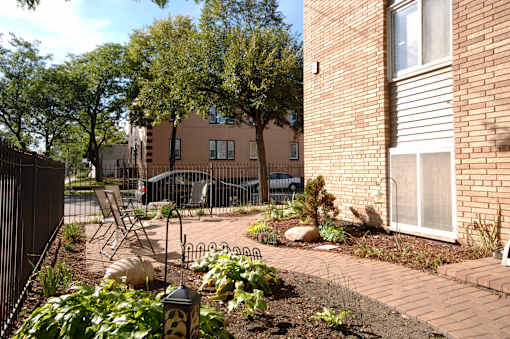 A brick building with a white window and a black fence.