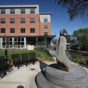 A statue of a woman is in front of a building.