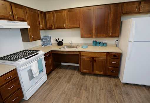 A kitchen with wooden cabinets and a white refrigerator.