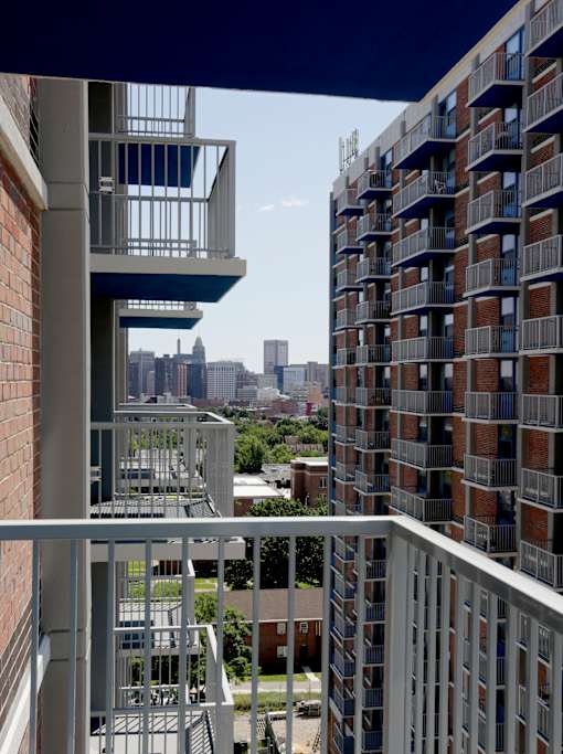A tall building with a balcony overlooking a city skyline.
