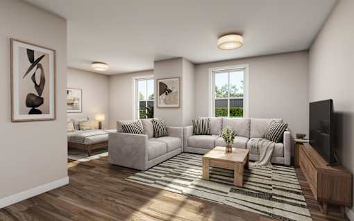 A living room with a grey sofa, a wooden coffee table, and a television on a wooden stand.