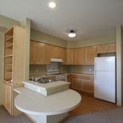 A kitchen with wooden cabinets and a white fridge.