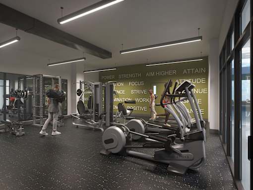 A gym with a variety of equipment and a sign that reads "POWER STRENGTH AIM HIGHER ATTAIN".