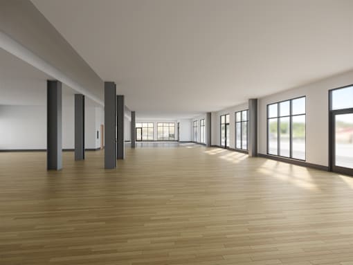 A room with wooden floors and large windows on one side.