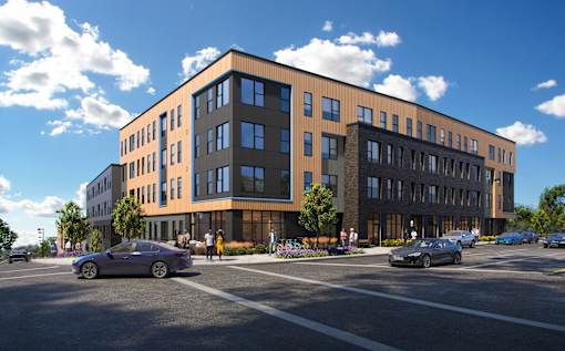 A modern building with a parking lot in front.