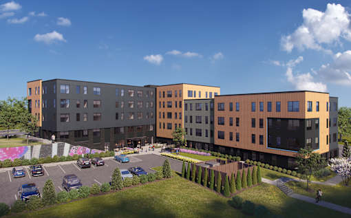 A modern apartment complex with a parking lot in front.