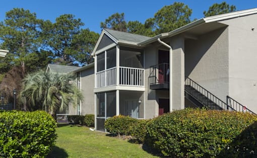 A two-story house with a balcony and stairs leading to the second floor.