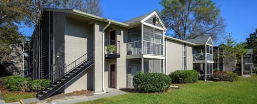 A grey apartment building with a black staircase.