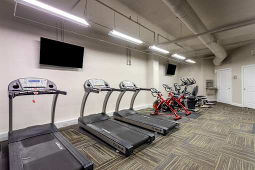 Gym with treadmills and bikes and a tv on the wall at 500 Fifth Apartments, Nashville, 37219