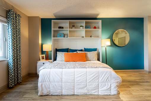 Bedroom with a bed and a blue wall and a window at 500 Fifth Apartments, Nashville
