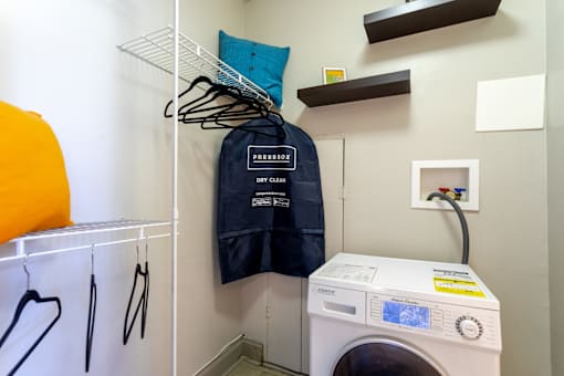 Laundry room with a washing machine and a jacket on a rack at 500 Fifth Apartments, Nashville, 37219