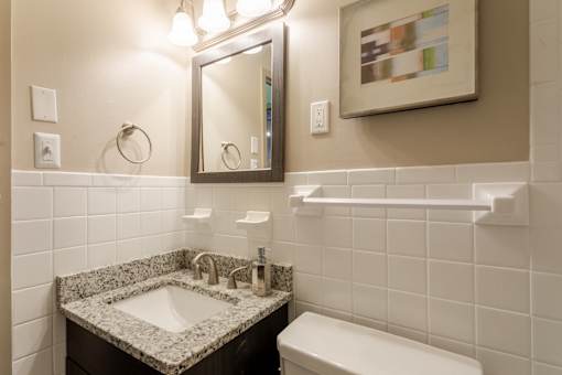 Bathroom with a sink and a mirror and a toilet at 500 Fifth Apartments, Nashville, TN, 37219