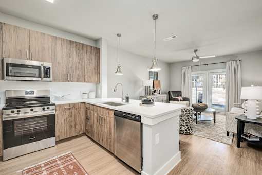 A modern kitchen with wooden cabinets and stainless steel appliances at The Ashton at East Park Apartments, Georgia, 30144